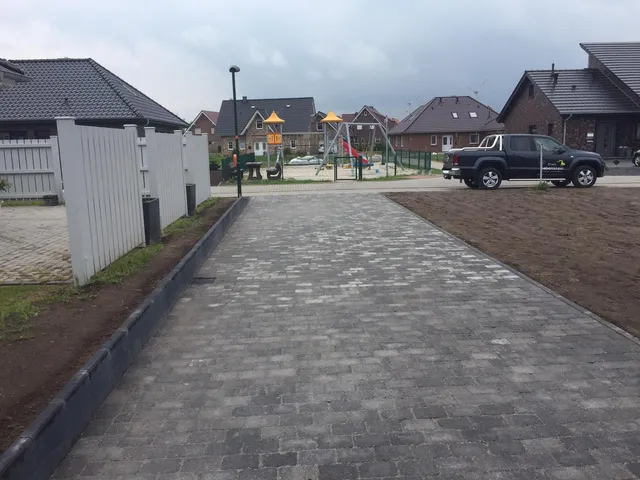 Gepflasterte Zufahrt mit eingefassten Rändern.